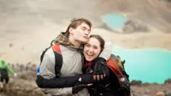 A happy couple at Tongariro Alpine Crossing, a popular tourist attraction in New Zealand.