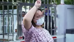 Protest leader Panusaya "Rung" Sithijirawattanakul, who has spent eight weeks in detention on charges of insulting the country"s king, shows a three-finger salut as she leaves after she was granted bail at the Central Women"s Correctional Institute in Bangkok, Thailand, May 6, 2021.