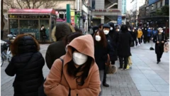 마스크를 받기 위해 줄 서 있는 사람들