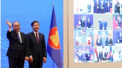 Vietnam"s Prime Minister Nguyen Xuan Phuc (L) and Minister of Industry and Trade Tran Tuan Anh (R) cheer after the virtual signing ceremony for the Regional Comprehensive Economic Partnership (RCEP) in Hanoi, Vietnam, 15 November 2020.