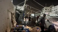 Alguns homens no que restou da tenda, em meio aos escombros