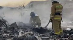 Emergency services battling fires amidst the wreckage.