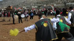 أكراد سوريون يرقصون ويحتفلون بعيد النوروز في منطقة عفرين، في 21 مارس/أذار 2025
