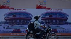 Motoqueiro passalampions bet casinofrente a painel do G20 que mostra foto e nomelampions bet casinocentrolampions bet casinoconvenções, Bharat Mandapam