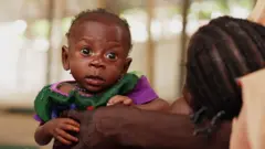 Ọmọ kekere ti iya rẹ gbe lọwọ