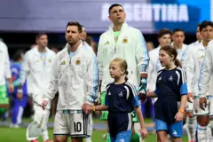 Messi e jogadores da Argentina entrando em campo ao lado de crianças