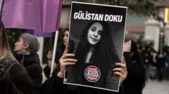 Gülistan Doku'nun siyah beyaz posterini tutan bir kadın eli protestoda yürüyen kadınlar. 