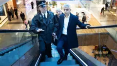 Agentes da polícia ao lado do prefeito de Londres, Sadiq Khan, no shopping Westfield, em 2024