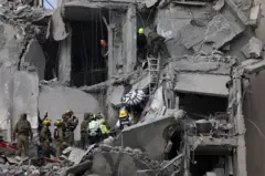 Prédio destruído em Israel, com equipes de resgate