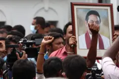 Pro-government supporters hold Prime Minister Mahinda Rajapaksa's portrait while protesting outside the prime minister’s residence on May 09, 2022 in Colombo, Sri Lanka. Sri Lankan President Gotabaya Rajapaksa has declared a state of emergency following escalating anti-government protests. Supporters of Sri Lanka’s ruling party have stormed a major protest site in Colombo, attacking anti-government demonstrators and clashing with police. Dozens of protesters have been injured.