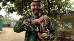 Professor Edem Archibong Eniag hold snake for hand