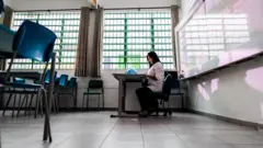 Professora em sala de aula vazia