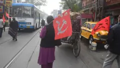 Ativistas do Partido Comunista da Índia (CPI) param veículos em uma estrada durante uma greve nacional contra as novas políticas trabalhistas introduzidas pelo governo central da Índia, em Calcutá.