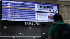 Um homem observa o painel de informações do aeroporto de Maiquetía.
