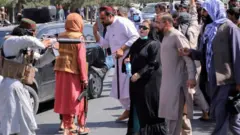 مقاتل لطالبان يواجه متظاهرين.