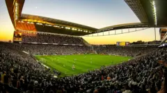 Arena Corinthians lotada de torcedores durante um jogo no por do sol