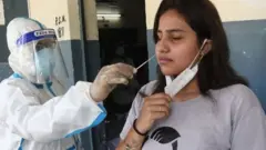 An Indian health worker takes swab samples for coronavirus and COVID-19 disease