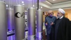 El presidente iraní Hassan Rouhani (derecha) escucha al jefe de la organización de tecnología nuclear de Irán, Ali Akbar Salehi, durante el "día de la tecnología nuclear" en Teherán.
