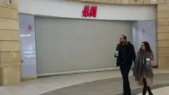 Пара йде поряд із закритим магазином