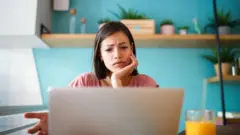 Une jeune femme devant son ordinateur