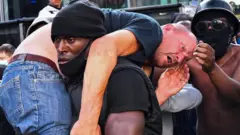 Patrick Hutchinson carries an injured demonstrator