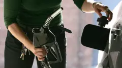 امرأة تملئ سيارتها بالوقود