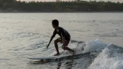 A young Indonesian boy surfing