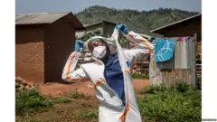 Une membre du personnel de santé enlevant sa combinaison.