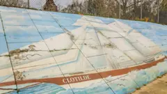 Une peinture murale représentant le navire négrier Clotilda longe l'autoroute qui sépare les deux côtés d'Africatown