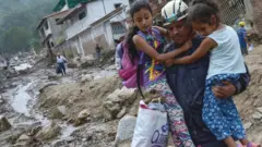 Rescatista con dos niñas en Tovar, Mérida, Venezuela.