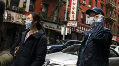 美國紐約唐人街街頭戴著口罩走過的華人居民（17/3/2020）