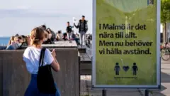 People enjoy the warm evening at Sundspromenaden in Malmo, Sweden, on May 26, 2020