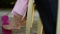 Les pieds d'une petite fille assise sur une chaine