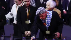 Выживший узник Аушвица с зажженной свечой 