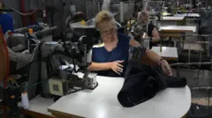 Operários confeccionam ternos na fábrica de roupas formais argentina "Confecciones Semana S.A.", em Buenos Aires, no dia 10 de fevereiro de 2026.