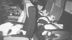 Foto em preto e branco mostra bebês desacompanhados presos a poltronas de avião