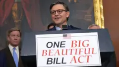 El presidente de la Cámara de Representantes de EE.UU. tras un cartel que hace referencia a la "grande y hermosa" ley presupuestaria.