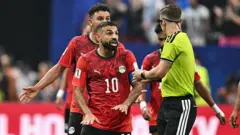 O jogador egípcio Mohamed Salah discute com o árbitro François Letexier, durante a partida da sua seleção contra a Argentina, pelas oitavas de final da Copa do Mundo de 2026