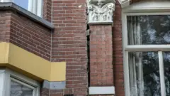 A fachada de tijolos de uma casa com uma grande rachadura.