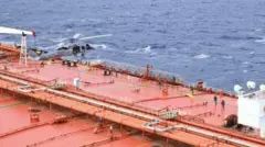 पेंटागन की ओर से एक्स पर पोस्ट की गई फ़ुटेज की एक तस्वीर, जिसमें एक अमेरिकी हेलीकॉप्टर को जहाज़ पर उतरते हुए दिखाया गया है