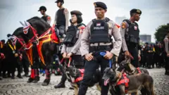 Polisi membawa anjing pelacak saat mengikuti apel Gelar Pasukan Operasi Lilin 2022 di Kawasan Monas, Jakarta, Kamis (22/12). 