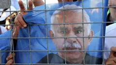 28 Haziran'da Diyarbakır'daki Özgürlük Mitingi'nde bir kişi PKK lideri Abdullah Öcalan'ın posterini elinde tutuyor ve zafer işareti yapıyor.