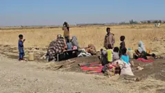  سودانيون نازحون بعد قضاء ليلة في مدينة القضارف شرق السودان.