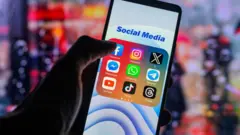 The Facebook app logo is being displayed on a smartphone among other social media networks 