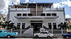 Fachada de igreja, com carros antigos estacionados na frente