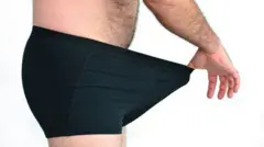 Homem estica cueca preta com a mão