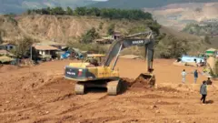 ဇန်နဝါရီ ၁၃ ရက်က အိမ်တွေ နစ်မြုပ်နေတဲ့ နွံနုန်းမြေပြင်ကိုဖယ်ရှားနေတဲ့ စက်ယန္တရားတွေ