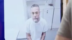 El médico palestino detenido, Hassam Abu Safiya, aparece en una pantalla vestido con una camisa blanca en prisión durante una audiencia ante la Corte Suprema israelí el 10 de junio de 2026.