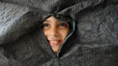 Renad espia através de um lençol preto