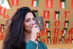 Một phụ nữ Kuwait giơ hộ chiếu của mình (hình minh họa)